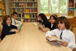 Alumnos leyendo un libro en la biblioteca William Caxton